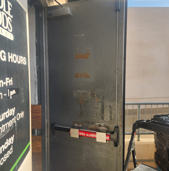 college-station-locksmith-servicing-commercial-door-img Locksmith in College Station servicing a commercial door