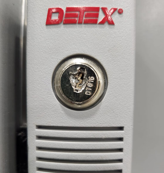 An Austin locksmith servicing a Detex commercial exit-device lock