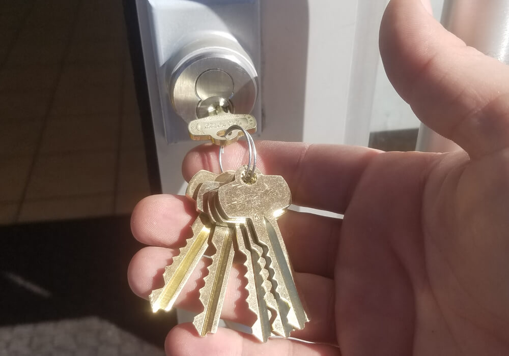 Texas locksmith holding freshly cut keys at front door