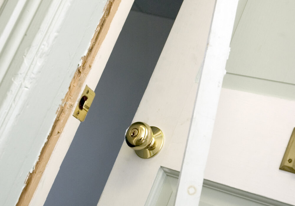 Split door jamb and damaged strike plate after a home break-in